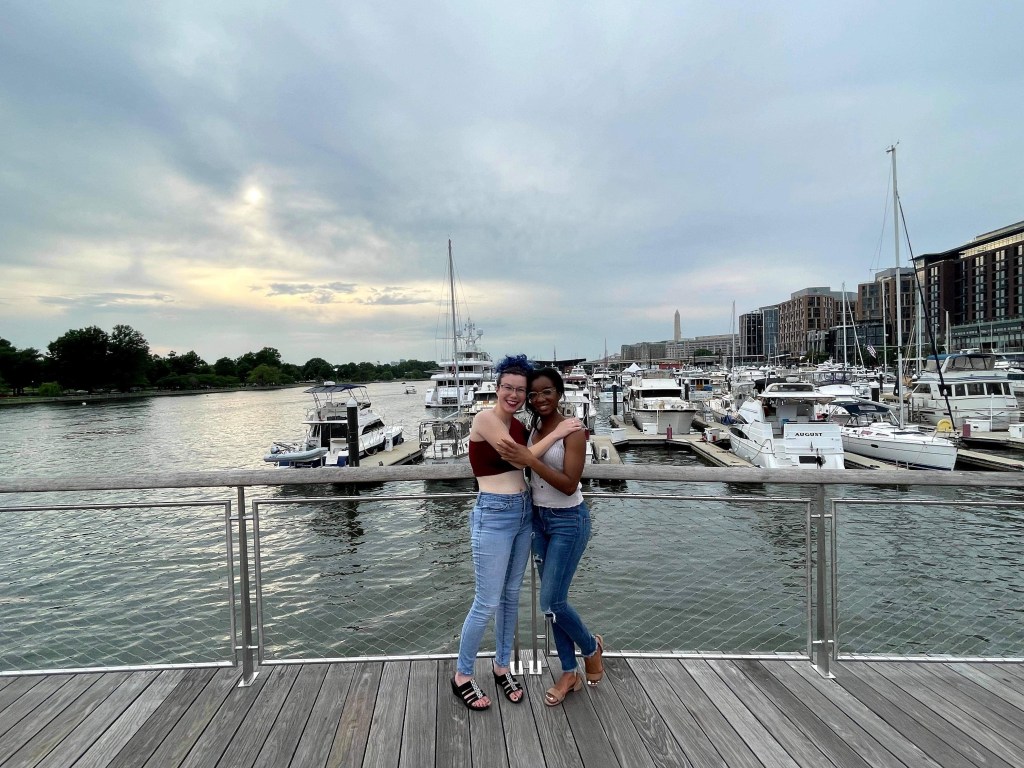 Two women pose in front of the docks in D.C.